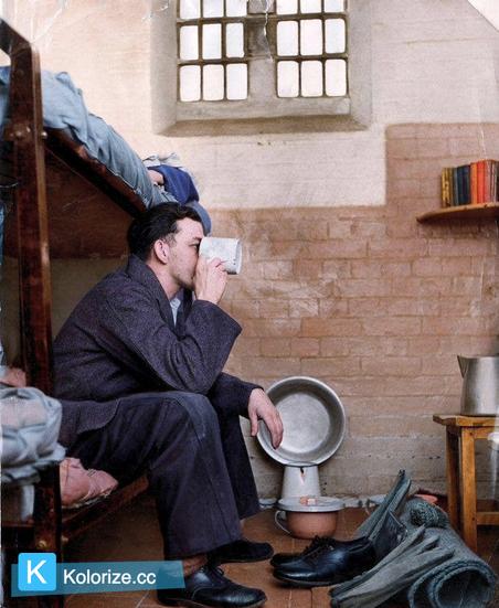 [colorized] A photograph of a prisoner in a typical cell at Leicester Prison 
Taken in 1959.