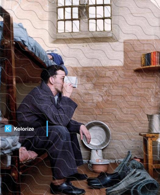 [colorized] A photograph of a prisoner in a typical cell at Leicester Prison 
Taken in 1959.