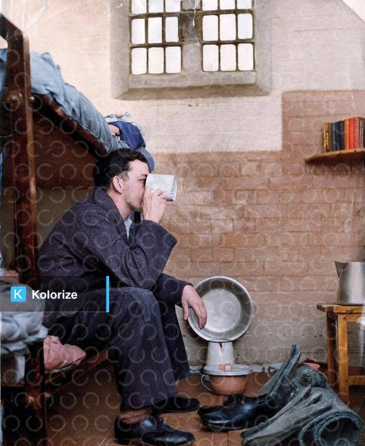 [colorized] A photograph of a prisoner in a typical cell at Leicester Prison 
Taken in 1959.