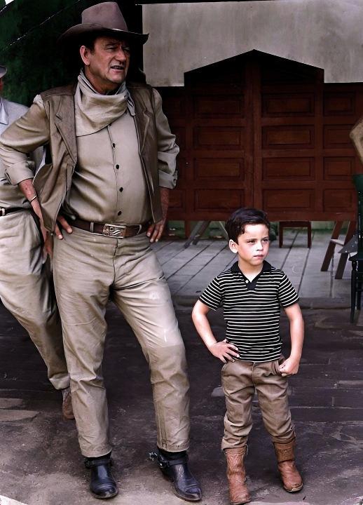 [colorized] John Wayne, with his son, on location in Mexico for the filming of “The War Wagon.”