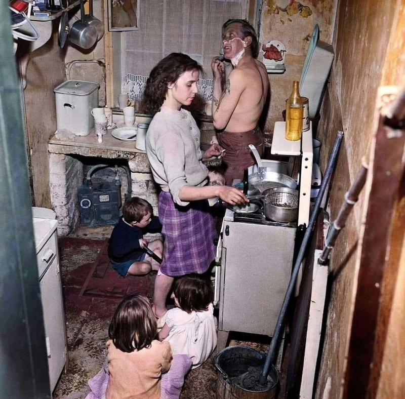 [colorized] A photograph of Mr Sutton Pownall, a gravedigger, with his wife Joyce and their five children in a 150 year old house at Number Two Court, Dickenson Street, Oldham. Taken on the 1st June in 1962