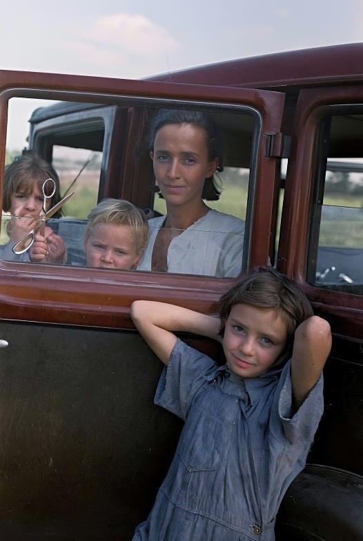 [colorized] A family of a migratory fruit worker from Tennessee camped in a field near the packinghouse at Winter Haven, Florida, 1937.