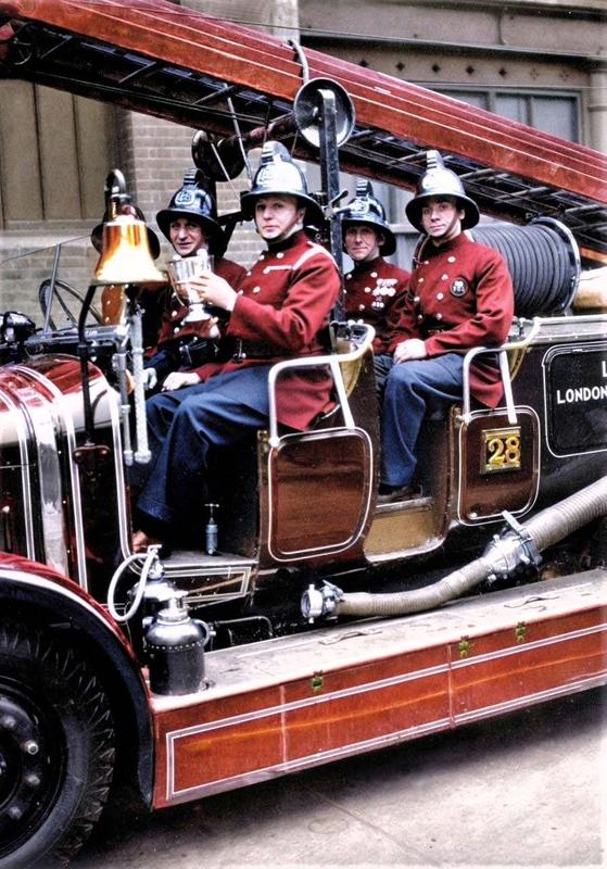 [colorized] A photograph from circa 1930 of Whitechapel fireman holding the trophy they won in the 'Fire Brigades Escape Competition'